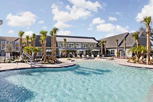 A swimming pool surrounded by palm trees and buildings.