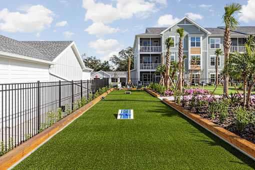 A grassy area with cornhole gamein the middle at Standard441 Luxury Apartments, Florida