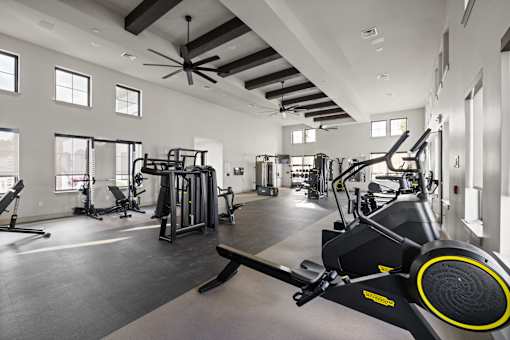 A spacious gym with a variety of equipment including treadmills, weights, and a rowing machine. at Terrassa Luxury Apartments, St. Augustine, Florida