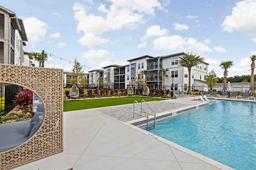 A pool area with a large building in the background. at Terrassa Luxury Apartments, St. Augustine