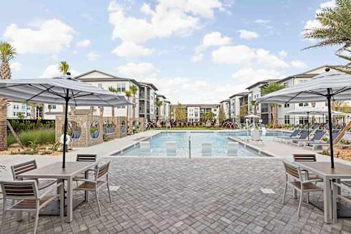A pool surrounded by chairs and umbrellas in a resort-like setting. at Terrassa Luxury Apartments, Florida, 32084