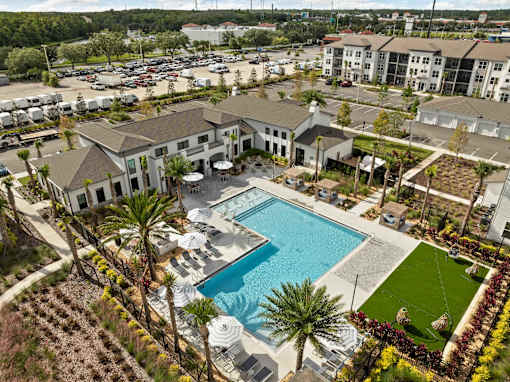 A large building with a pool in the middle of a grassy area. at Terrassa Luxury Apartments, Florida, 32084
