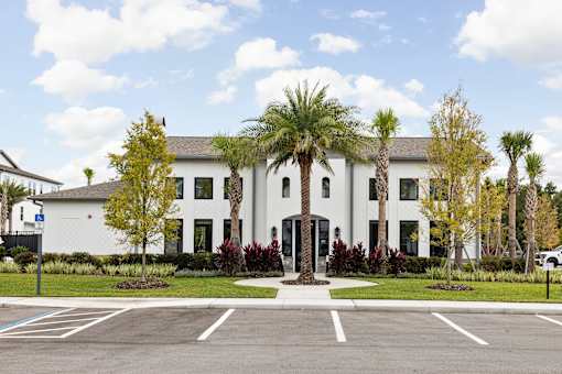 A white building with a parking lot in front. at Terrassa Luxury Apartments, St. Augustine, Florida