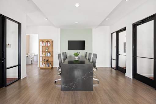 A conference room with a long table and chairs.