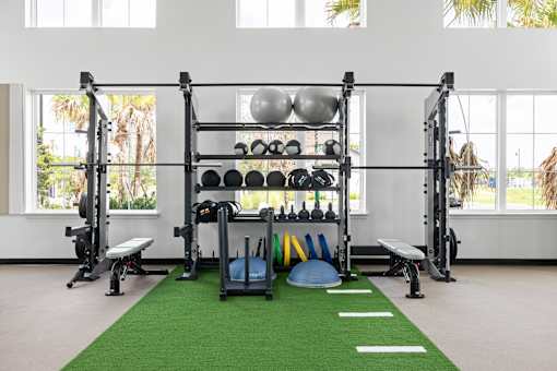 A gym with a green mat and weights.
