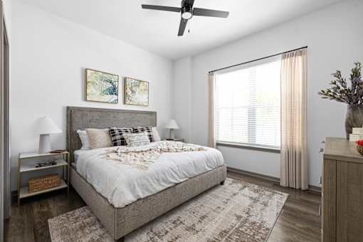 A bedroom with a large bed and a ceiling fan.