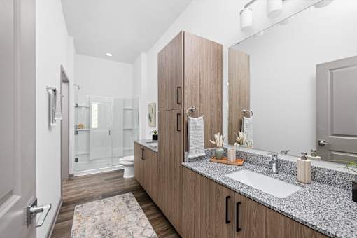 A bathroom with a sink, mirror, and cabinets.