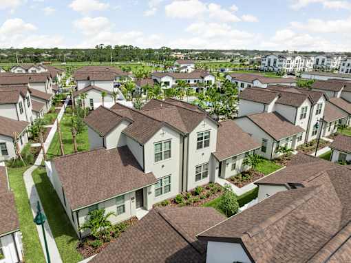 A cluster of houses with brown roofs and white walls.
