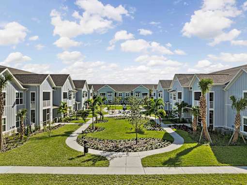 A row of houses with a garden in the foreground. at Junction Apartments in Rockledge, FL