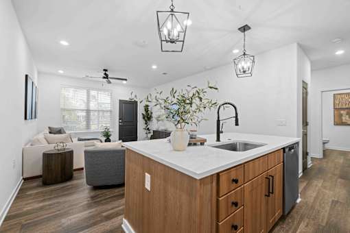 A modern kitchen with wooden cabinets and a white countertop. at Junction Apartments in Rockledge, FL
