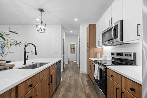 A modern kitchen with wooden cabinets and stainless steel appliances. at Junction Apartments in Rockledge, FL