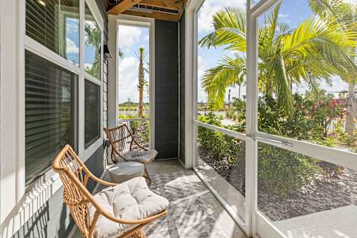 A balcony with a chair and a table. at Junction Apartments in Rockledge, FL