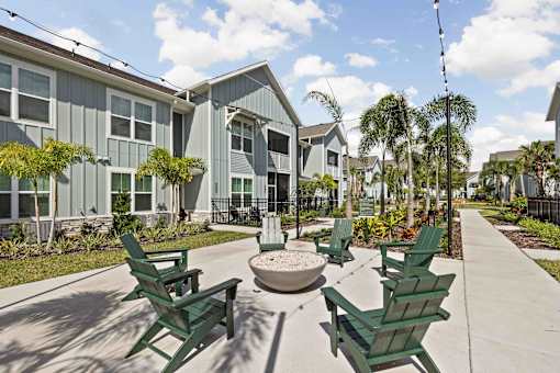 A sunny day at a residential area with green chairs and a fountain. at Junction Apartments in Rockledge, FL