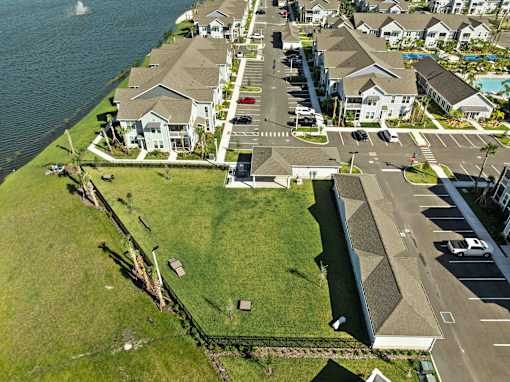 A bird's eye view of a residential area with houses, a road, and a body of water. at Junction Apartments in Rockledge, FL