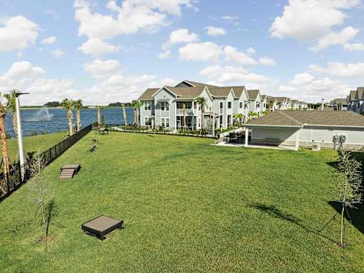 A grassy area with a fence and a body of water in the background. at Junction Apartments in Rockledge, FL