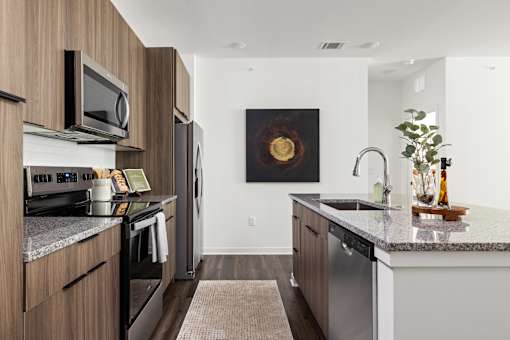 A modern kitchen with a dark wood finish. at The Levi Luxury Apartments, McDonough, GA