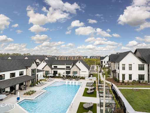 A large white building with a pool in front. at The Levi Luxury Apartments, McDonough, GA