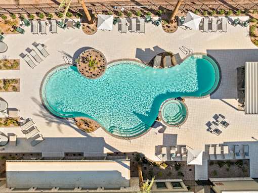A large swimming pool surrounded by lounge chairs and umbrellas.