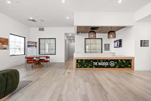 A reception area with a green wall and a sign that says "The Maddox".