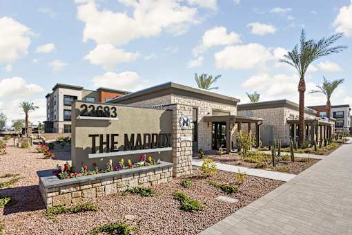 The Maddox sign is in front of a building with a clear blue sky in the background.