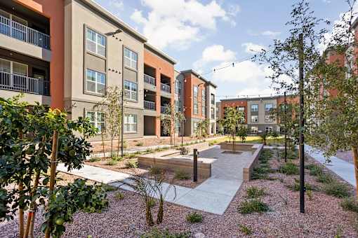 A modern apartment complex with a courtyard and trees.