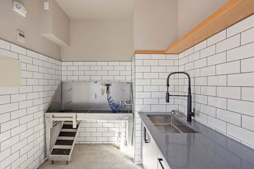 A kitchen with a sink and a stainless steel counter.