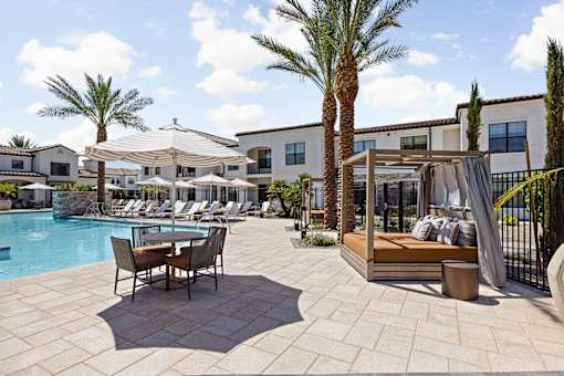 A poolside area with a table and chairs.at Stella, San Tan Valley Arizona