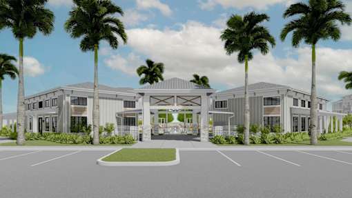 A modern building with a white facade and palm trees in front at Verity Luxury Apartment Homes, Vero Beach, Florida
