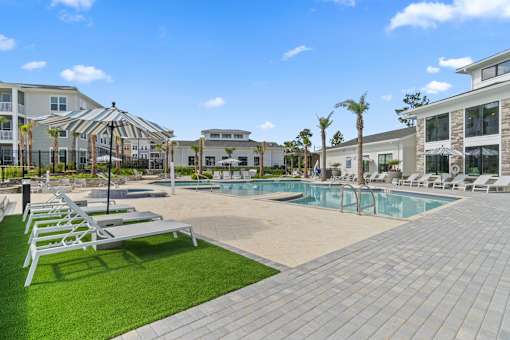 Pool With Relaxing Chairs at The Quinn Luxury Apartments, Pensacola, FL