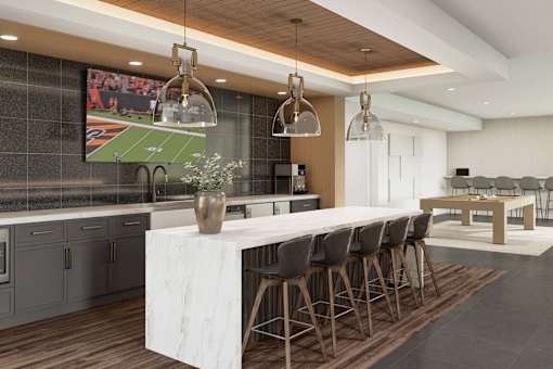 A modern kitchen with a long white marble island and dark wood floors. at Stack at Wheat Ridge Apartments, Wheat Ridge