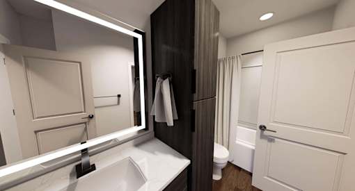 A bathroom with a sink, mirror, toilet, and shower at Stack at Wheat Ridge Apartments, Wheat Ridge