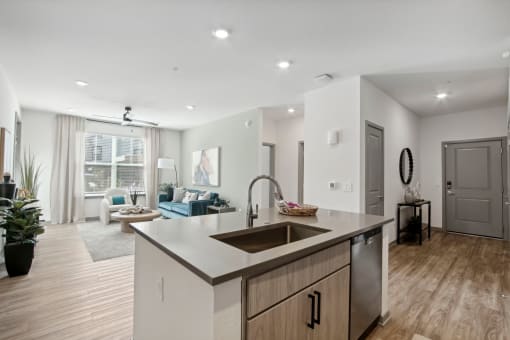 an open kitchen and living room with a large window and a sink at The Maddox Luxury Apartment Homes, Buckeye, AZ  