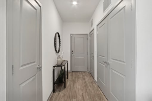 a hallway with white walls and white doors and a door to a closet at The Maddox Luxury Apartment Homes, Arizona  