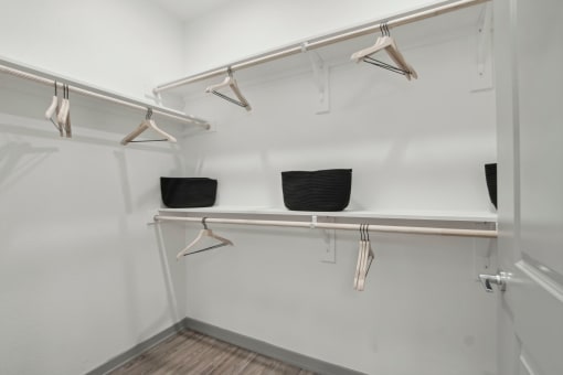 a walk in closet with shelves and hangers on the wall at The Maddox Luxury Apartment Homes, Buckeye  