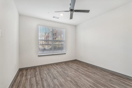 an empty living room with a ceiling fan and a window at The Maddox Luxury Apartment Homes, Buckeye, AZ 85326  