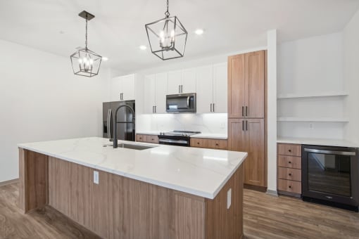 a white kitchen with wooden cabinets and a white counter top at The Maddox Luxury Apartment Homes, Buckeye, 85326  