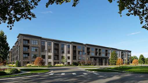 A large apartment complex with a parking lot in front.