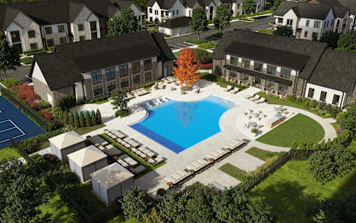 A large swimming pool surrounded by a grassy area and buildings.