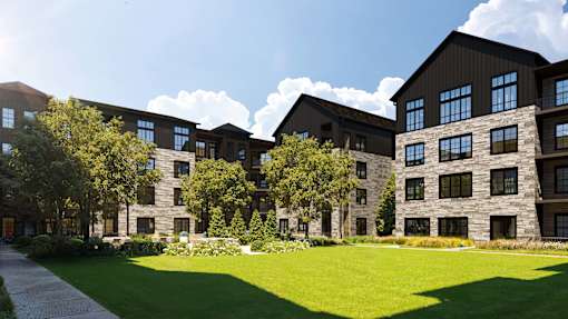 A large building with a green lawn in front.