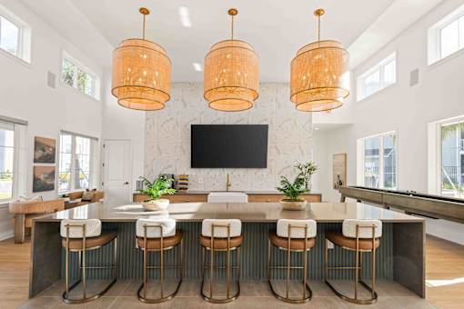 A kitchen with a bar area and a television mounted on the wall at Verity Luxury Apartments, Florida 32960