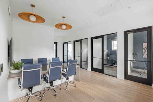 A conference room with blue chairs and wooden floors at Verity Luxury Apartments, Vero Beach, 32960