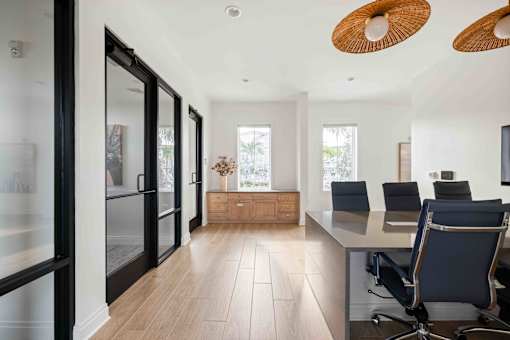 A modern office with a glass wall and a wooden floor at Verity Luxury Apartments, Vero Beach, FL