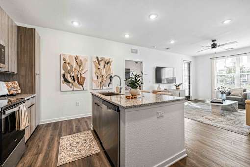A modern kitchen with a large island and a painting on the wall at Verity Luxury Apartments, Florida 32960