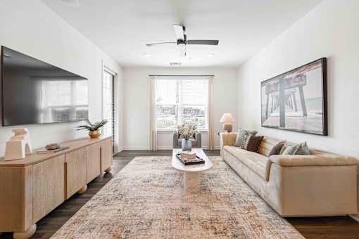 A living room with a rug, a couch, a coffee table, and a painting on the wall at Verity Luxury Apartments, Florida