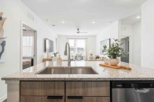 A modern kitchen with a granite countertop and stainless steel appliances at Verity Luxury Apartments, Vero Beach, FL 32960