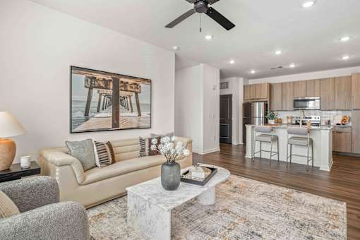 A living room with a couch, a coffee table, and a painting on the wall at Verity Luxury Apartments, Vero Beach, FL