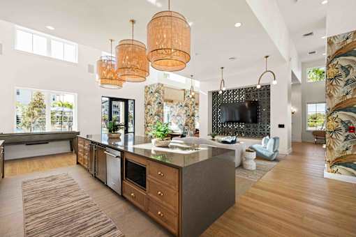 A modern kitchen with a large island and wooden floors at Verity Luxury Apartments, Vero Beach, Florida