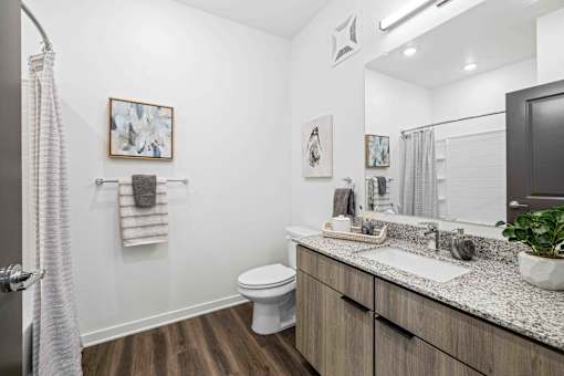 A bathroom with a white toilet and a sink at Verity Luxury Apartments, Vero Beach