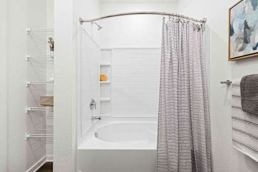 A white bathroom with a shower curtain and a white tub at Verity Luxury Apartments, Florida