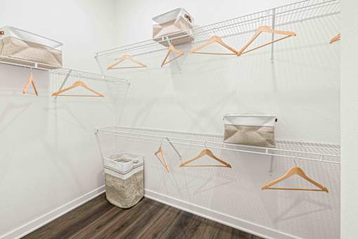 A white closet with orange hangers and a trash can at Verity Luxury Apartments, Vero Beach, 32960